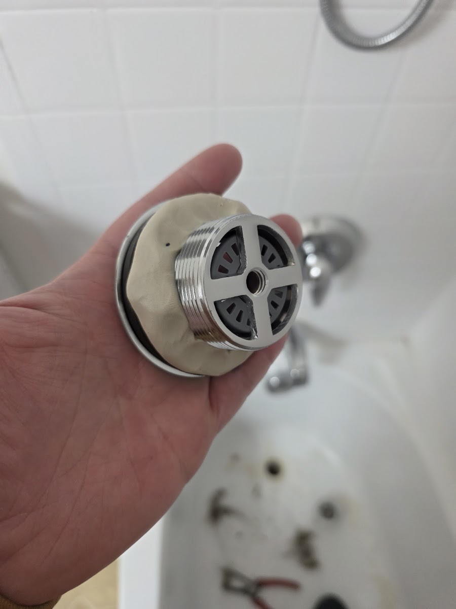Tub drain and overflow assembly being installed during a bathroom repair